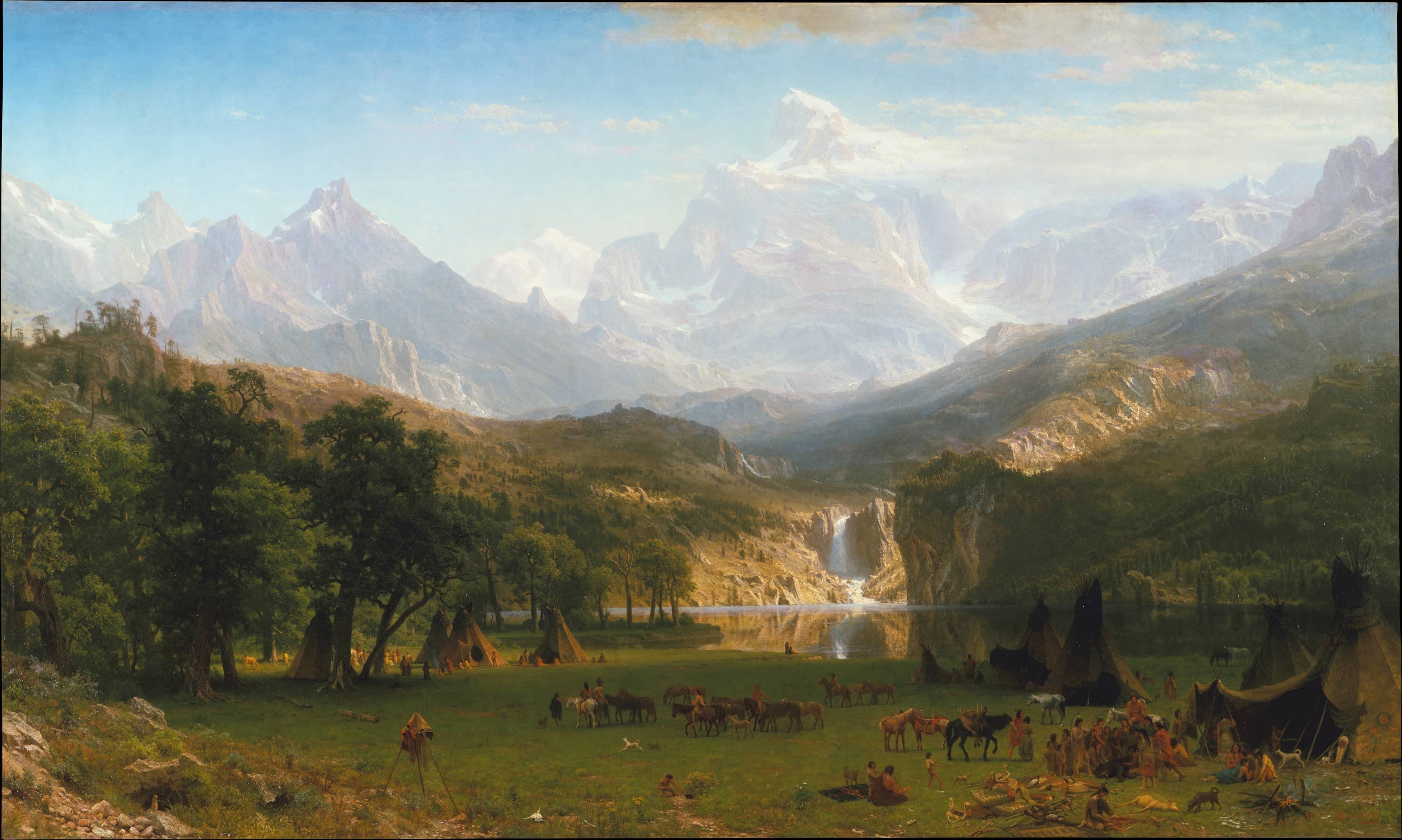 Snow capped mountains overlooking a valley and river.